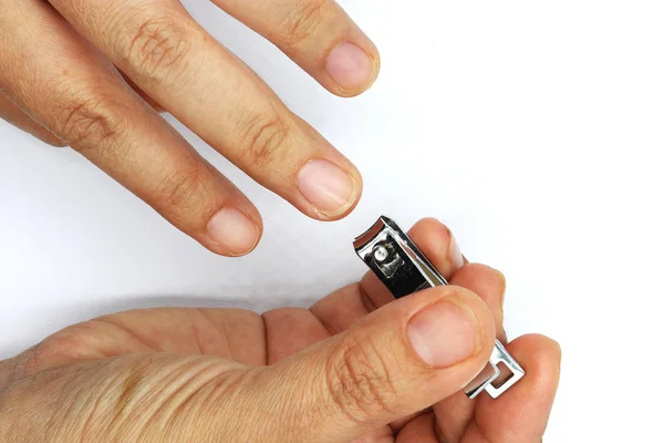 Woman cutting nails using nail clipper isolated on black backgro