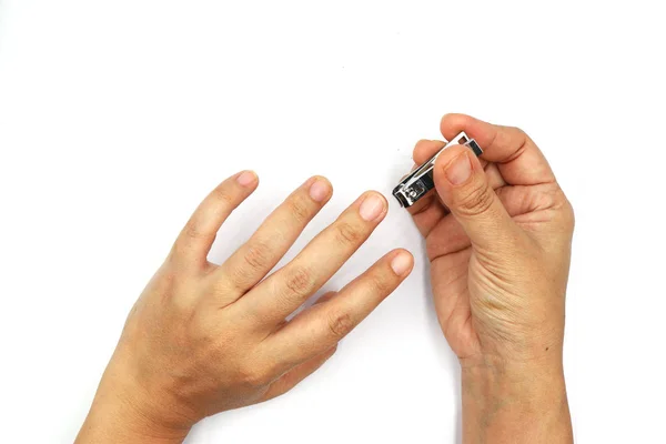 Woman cutting nails using nail clipper isolated on black backgro — Stock Photo, Image