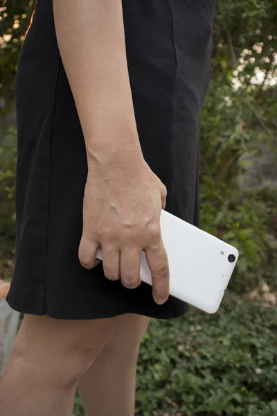 Asiatische Frau halten und mit Smartphone zeigen Rückseite. — Stockfoto