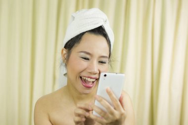 Telefonla oynayan bir kadın. Elbisesini örtmek için etek giyiyor.