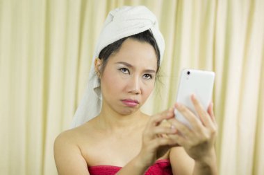 Telefonla oynayan bir kadın. Elbisesini örtmek için etek giyiyor.