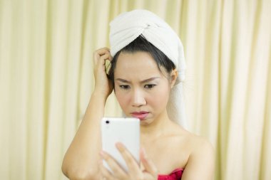 Telefonla oynayan bir kadın. Elbisesini örtmek için etek giyiyor.