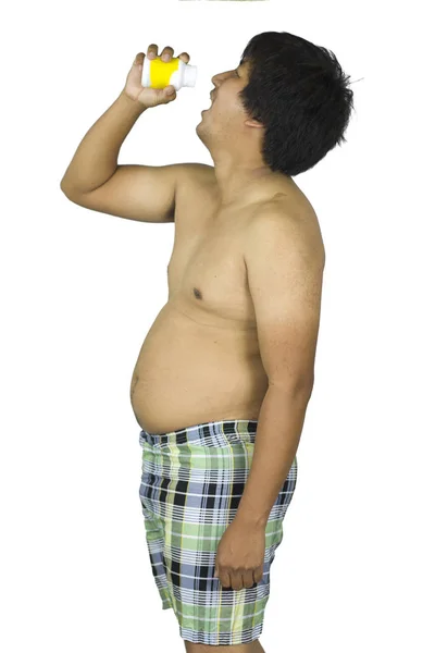 Gordo chico sosteniendo un amarillo tarro de píldoras en blanco aislado backgrou — Foto de Stock