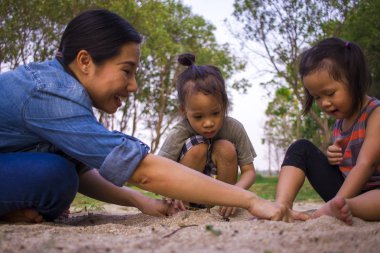 Yaşam tarzı portre anne oğlu ve kızı kum, Funn ile oynarken