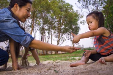 Yaşam tarzı portre anne oğlu ve kızı kum, Funn ile oynarken