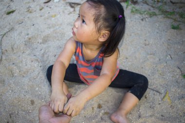 Kum ile oynayan mutlu çocuk, bir parkta Komik Asya lı aile.