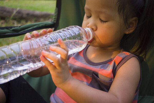маленькие дети пьют воду из бутылки в зеленом парке
.