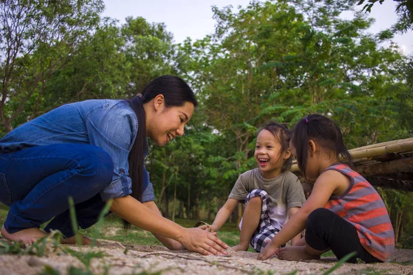 Yaşam tarzı portre anne oğlu ve kızı kum, Funn ile oynarken
