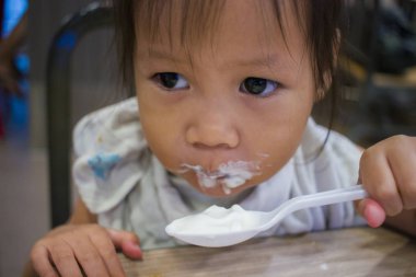 Mutfakta kaşıkla olan çocuk buz çığlıkları yiyor.