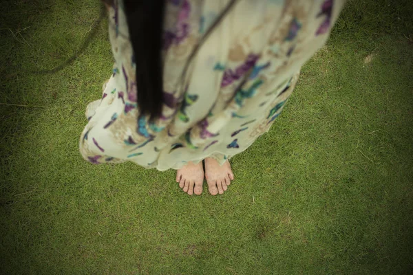 Ung kvinna barfota gå på färska, grönt gräs i solsken — Stockfoto