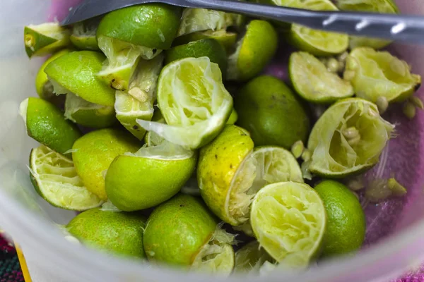 Squeeze the lemon peel, green lemon in plastic cup.