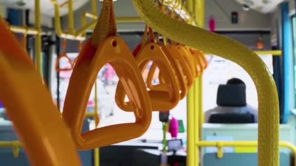 sárga lógó kapaszkodók álló utasok egy modern buszon. Külvárosi és városi közlekedés