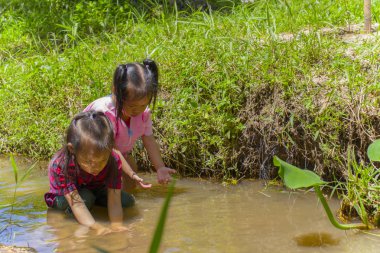 Asya Çocuklar dere suda yalınayak oynarken, çamur ve s oynamak