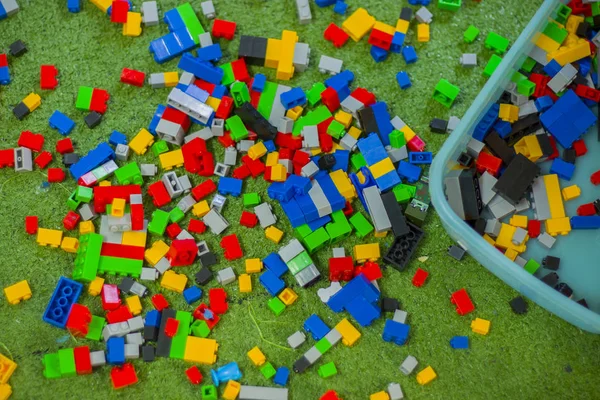 Gekleurde speelgoed bakstenen met plaats op groene grond zeer rommelig. — Stockfoto