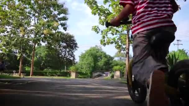 Niños en bicicleta equilibrio en carretera de asfalto en el parque . — Vídeo de stock