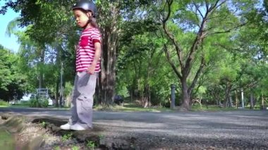 çocuklar yaz aylarında mavi gökyüzü sırasında bir weeds üzerinden koşmak ve atlamak. Küçük akışı geçe.
