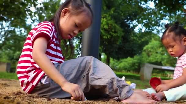 Kinder spielen gemeinsam Sand, lustige asiatische Kinderfamilie auf einem öffentlichen Spielplatz. — Stockvideo