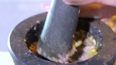 Kadınlar gıda pişirme için harç baharat ve otlar vurma, tayland popüler gıda harç ve baharat salçası ile havaneli tutun
