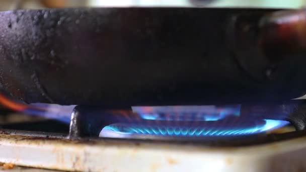 Gas brennt aus einem schmutzigen Gasherd in der Küche mit schwarzer Pfanne. — Stockvideo
