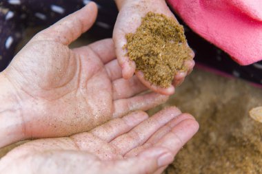 Yaşam tarzı portre anne oğlu ve kızı kum, Funn ile oynarken