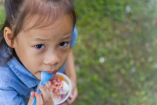 Thai/Asian cute little kids eating Ice cream in a cup or mango b