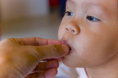 Baba kızını el ve kaşıkla besliyor..