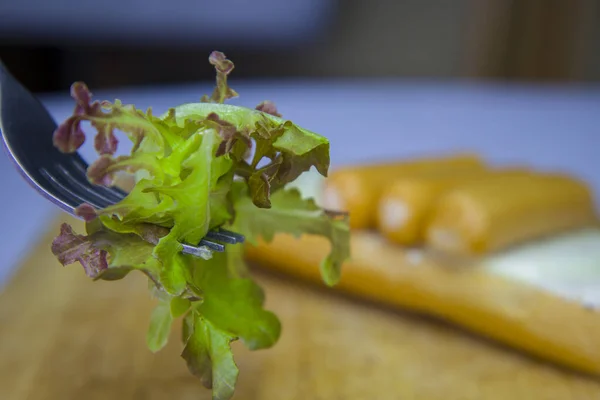 Salat aus Gemüse und Gabel auf Wurst. — Stockfoto