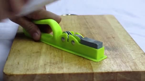Muž nabrousit nůž v domácí kuchyni — Stock video