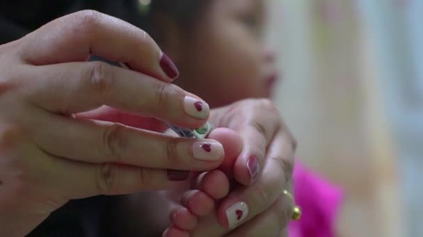 Moeder proberen naar nagel snijden voor haar dochter. — Stockvideo