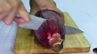 Muz çiçeğini soyan adamın elleri, muz tomurcuğunu aşçılığa ya da salataya hazırlayın..