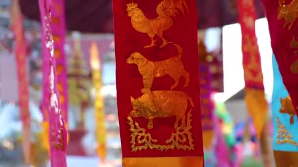 The astrologious papers hanged up in front of worship's house for tourist to make offerings to the spirits.12 animal pictures (follow to the birth year) at Chiangmai Thailand. — Stock Video