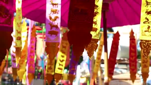 The astrologious papers hanged up in front of worship's house for tourist to make offerings to the spirits.12 animal pictures (follow to the birth year) at Chiangmai Thailand. — Stock Video