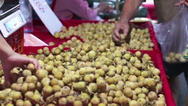 Wollongong Thai frukt är frukten av södra Thailand. Har en gul färg, söt smak. Thailändare kallar "Wollongong". på nattfruktsmarknaden Lamphun Thailand. — Stockvideo