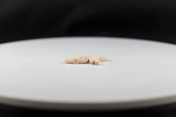 orange long pills capsules of vitamins for health on a white background