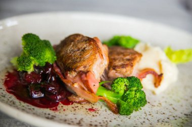 Pastırmalı et madalyonu, brokoli ve hafif bir tabakta kiraz.