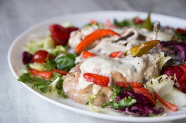 Sebze ve çilekle servis edilen kremalı sosta pişirilmiş tavşan.