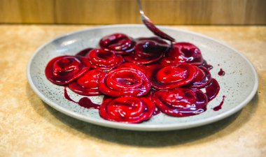 Kırmızı soslu ravioli şef tarafından tabakta servis edilir.