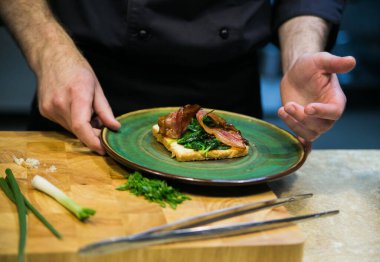 Ispanaklı tost ve pastırma bir erkek tarafından servis edilir.