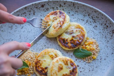 Bir tabakta servis edilen ballı peynirli kekler.