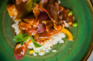 Et yahnisi ve sebzeli risotto kil tabakta çok güzel servis edilir.