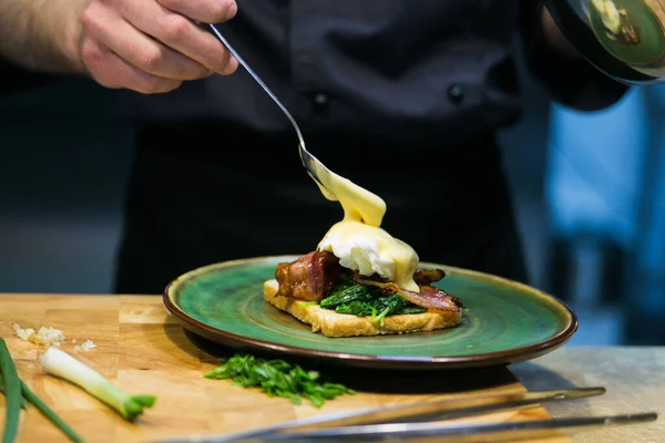 Ispanaklı tost ve pastırma bir erkek tarafından servis edilir.