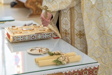 Wedding rings on a table with an open bible and candles