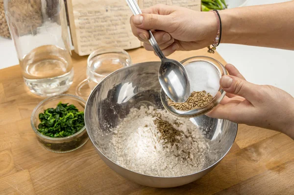 Metal bir kasede hamur hazırlamak ve malzemeler eklemek.