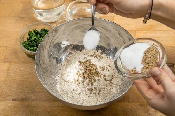 Metal bir kasede hamur hazırlamak ve malzemeler eklemek.