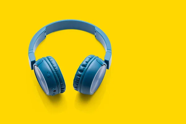 蓝牙蓝色耳机在黄色背景工作室产品特写设备 — 图库照片