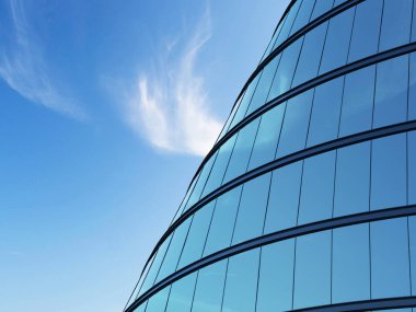 3d yüksek katlı eğri cam bina ve mavi gökyüzü arka plan üzerinde koyu çelik pencere sistemi teşvik, Gelecekteki mimari İş kavramı, binanın açısına bakmak.