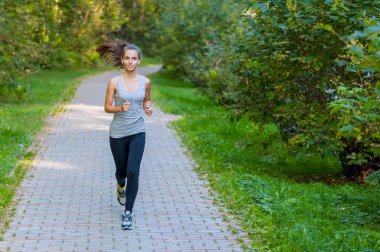 Yaz parkında atletik atletizm antrenmanları yapan bir kadın. Açık hava fitness portresi