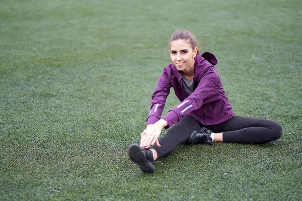 Germe kadın. Genç kadın egzersiz fitness eğitim oturumu bir futbol sahası üzerinde önce. Açık havada kadar ısınma sağlıklı genç kadın.