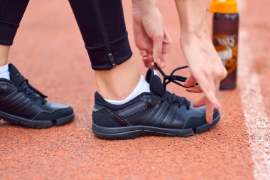 runner kadın çalışma parça Stadı şişe su ile yarış için hazırlanıyor koşu ayakkabıları dantel bağlama