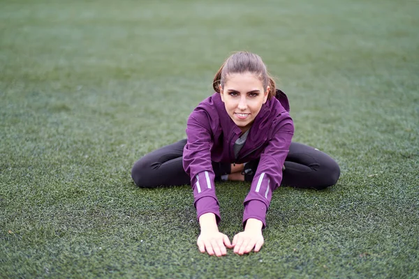 Germe kadın. Genç kadın egzersiz fitness eğitim oturumu bir futbol sahası üzerinde önce. Açık havada kadar ısınma sağlıklı genç kadın.
